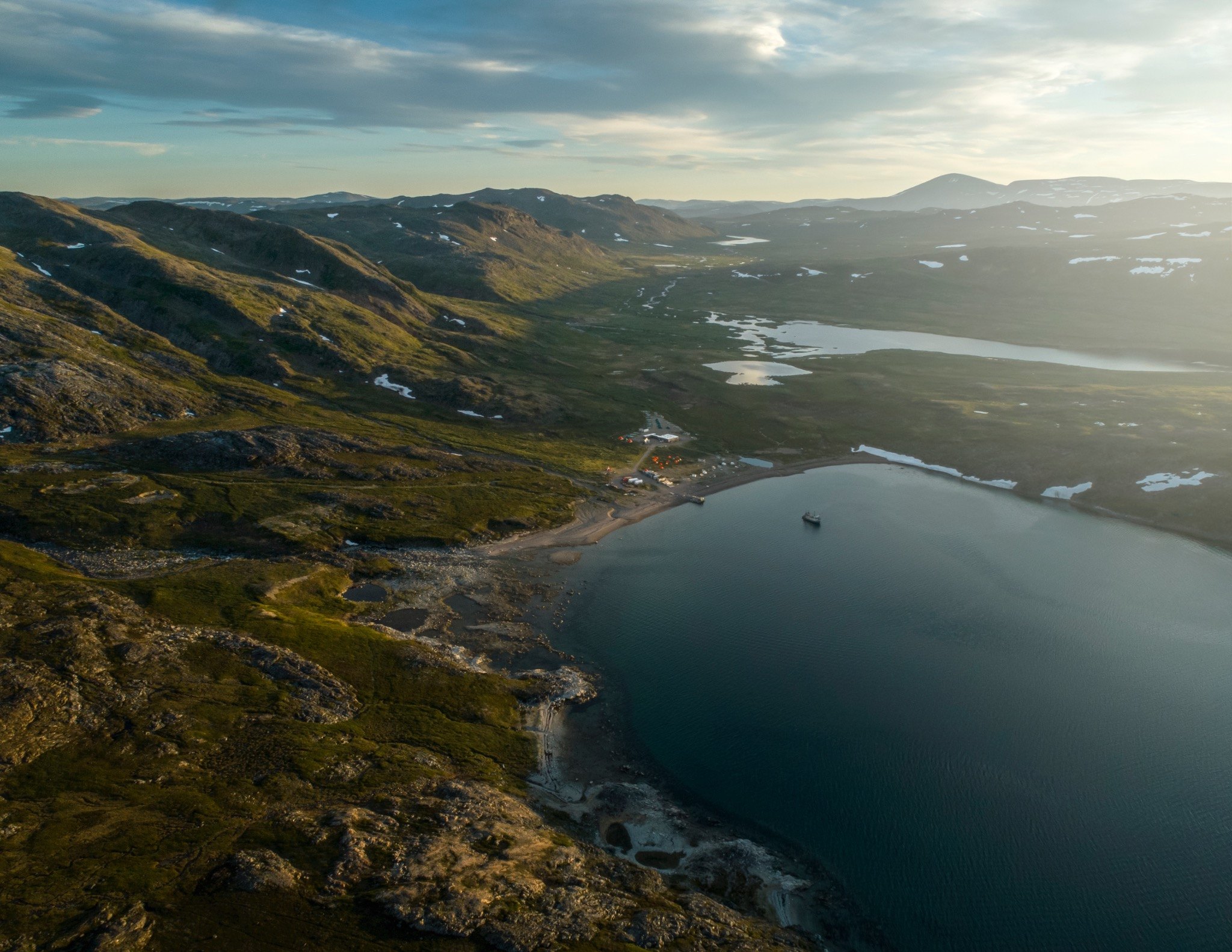 Aerial view of a remote northern field camp surrounded by mountains and lakes