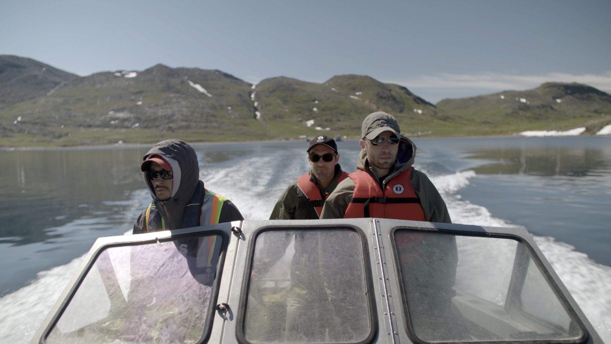 Field team travelling by boat through a northern mountain landscape