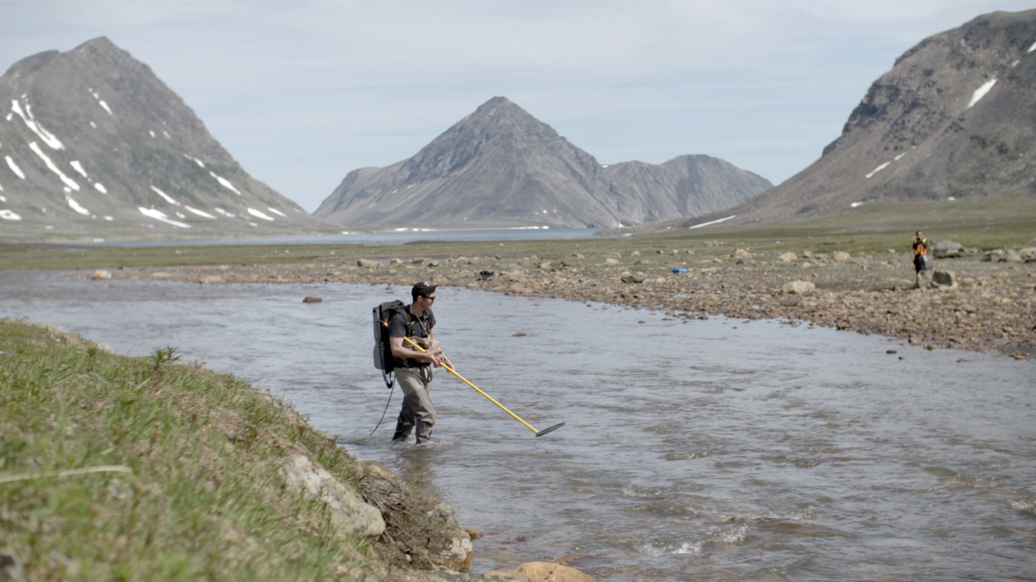 Electrofishing survey in a northern river framed by mountains