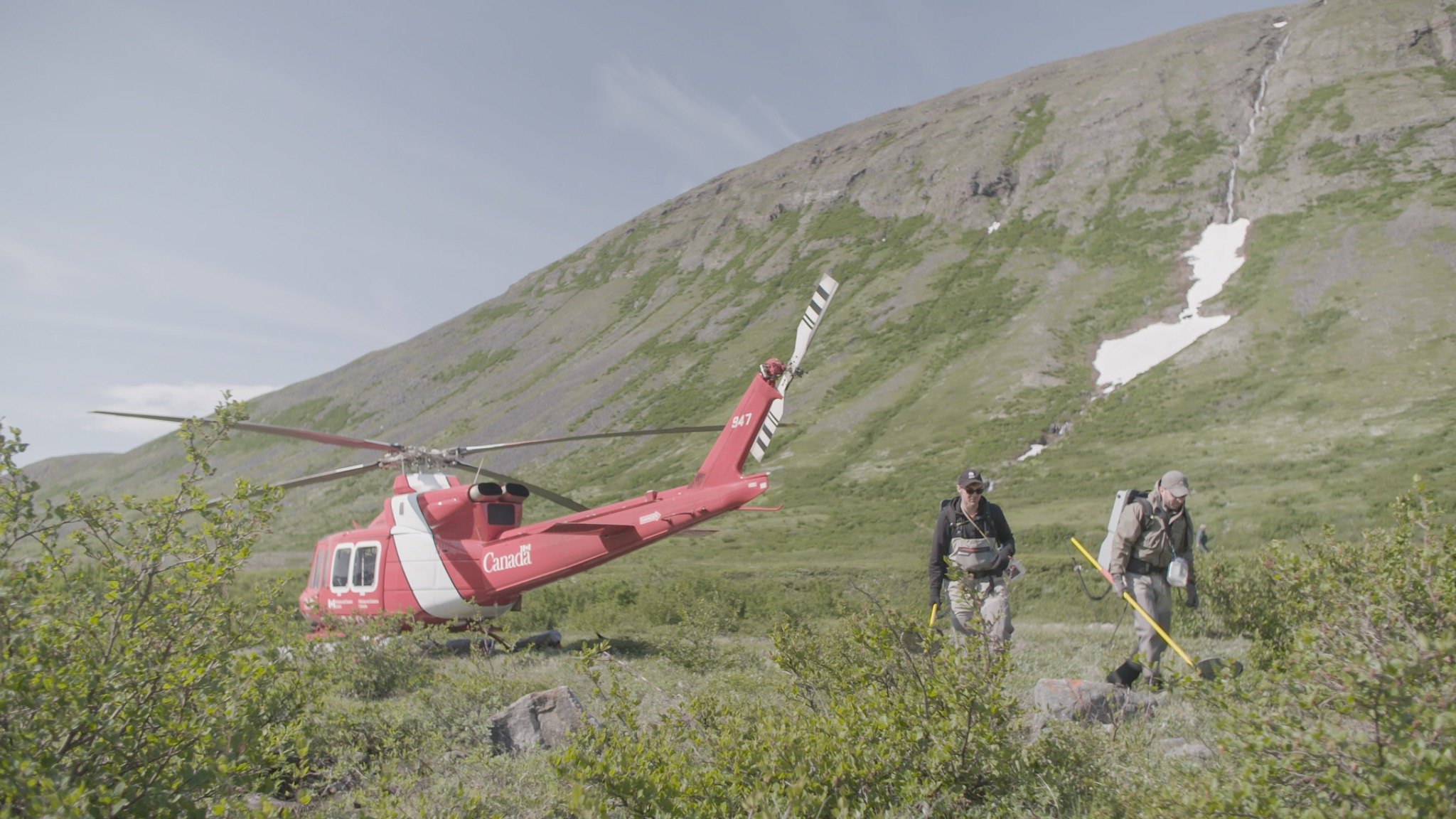 Field researchers deploying from a helicopter with sampling equipment