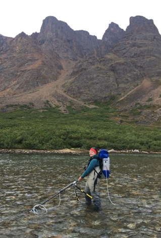Electrofishing field sampling beneath a dramatic northern mountain landscape